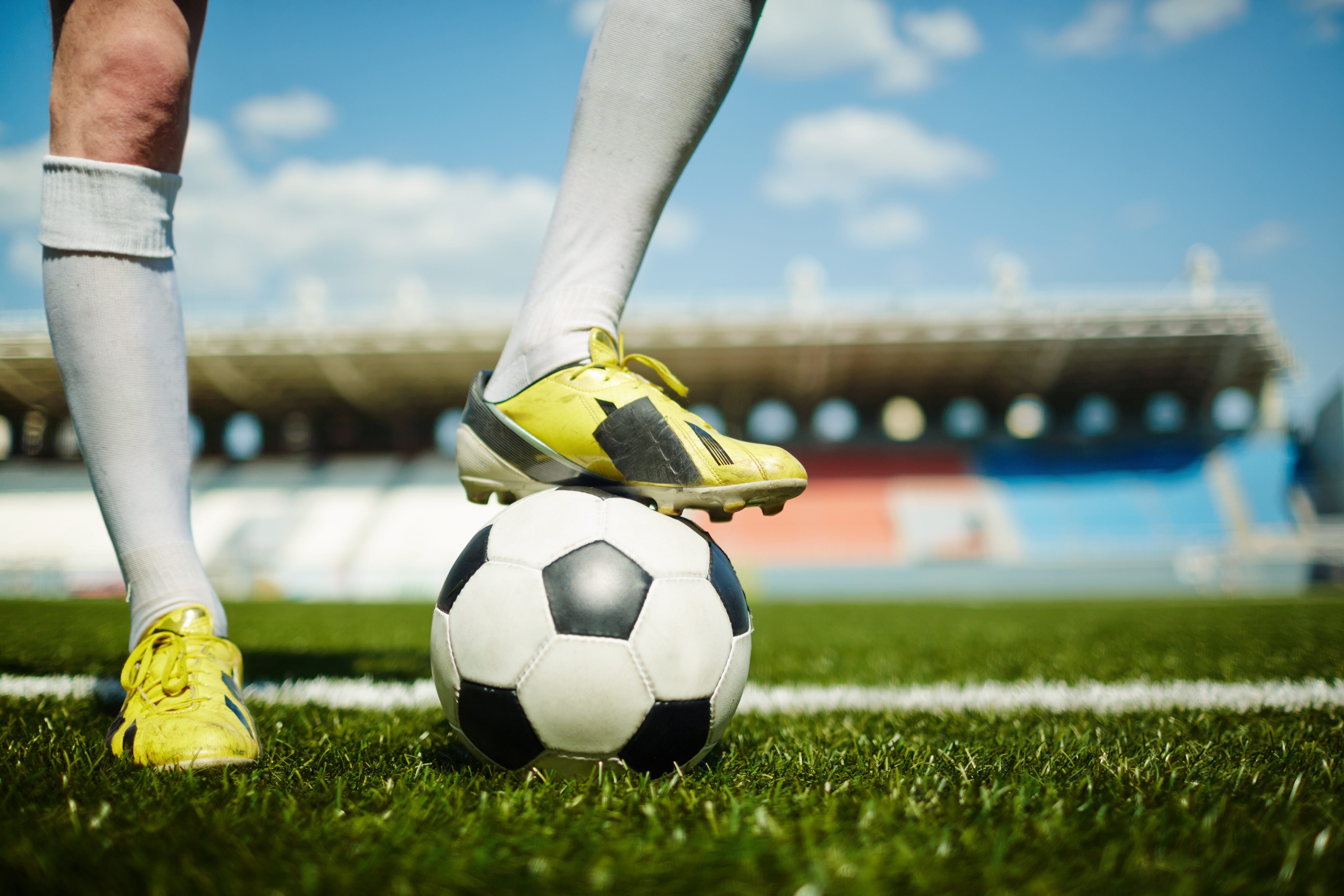 Pessoa no gramado pisando em uma bola de futebol, representando palpites de futebol para hoje com odds do Campeonato Brasileiro