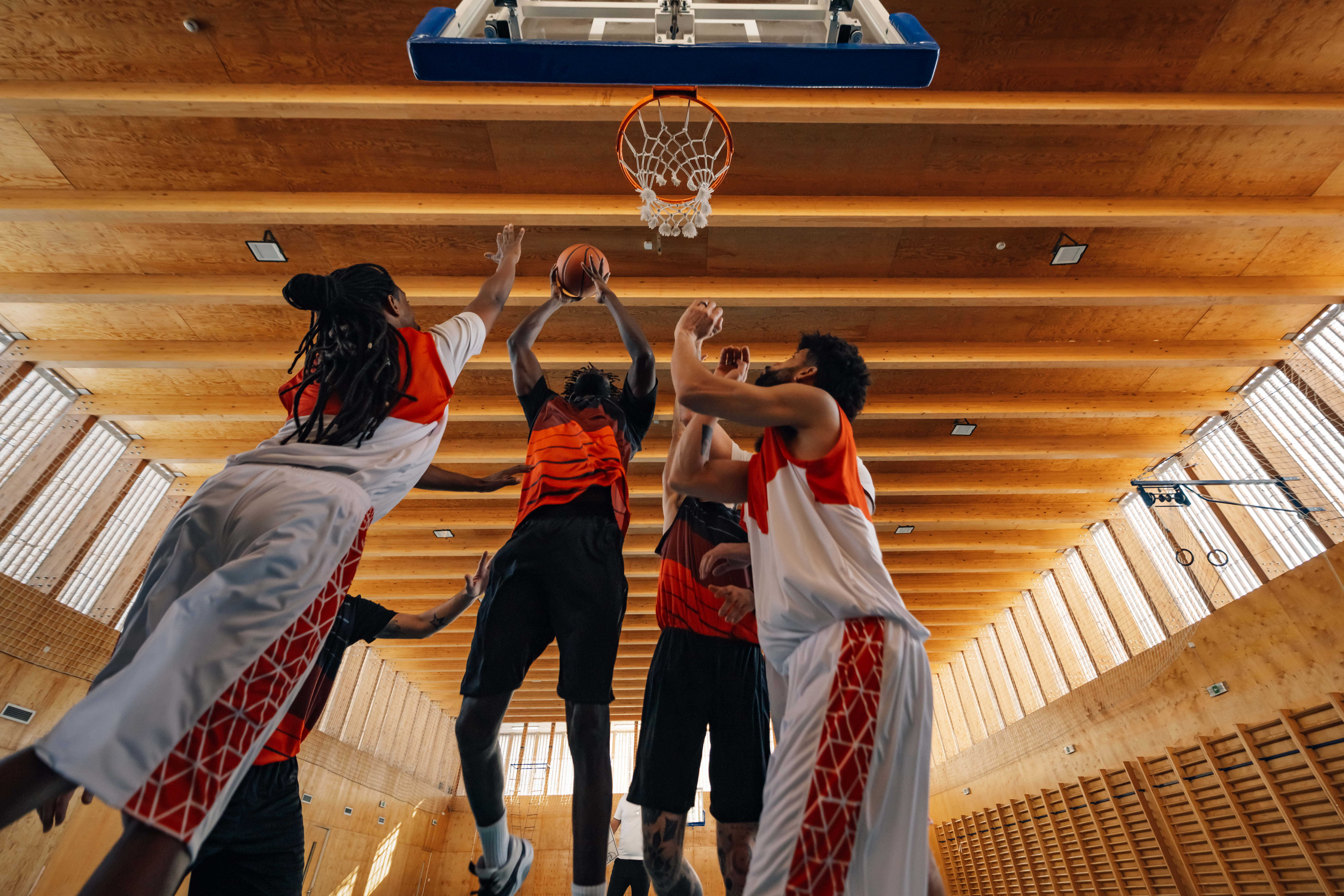 Jogadores disputam uma cesta durante partida de basquete em quadra coberta, simbolizando a intensidade e o equilíbrio das apostas com handicap basquete.